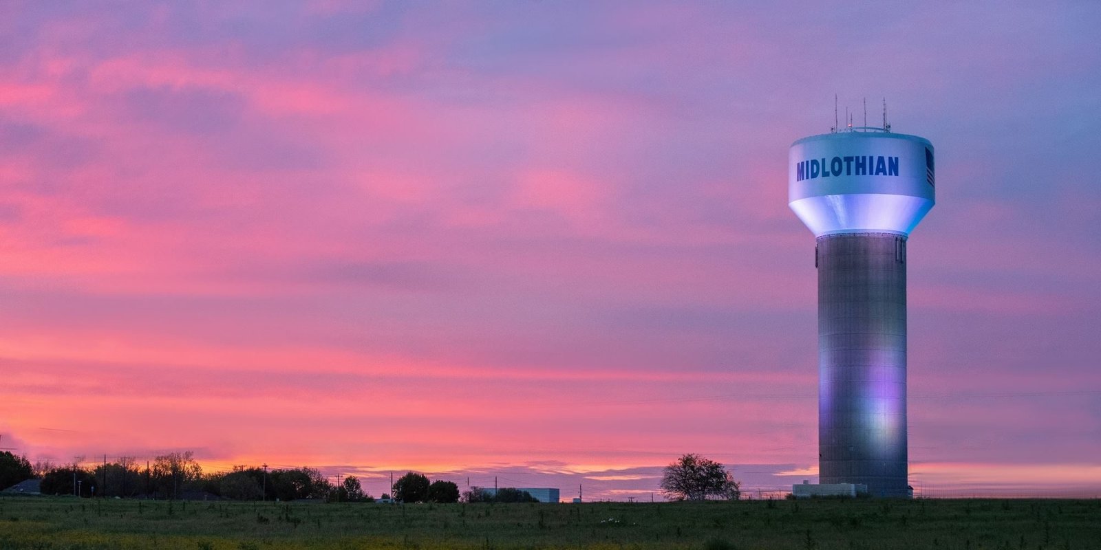 Midlothian, Texas water tower at sunset over Ellis County fields